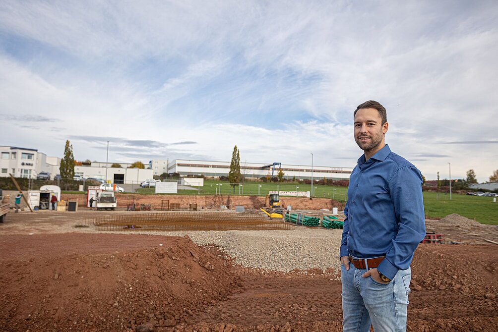 Christoph Stolze vor etwa einem Jahr auf der RoBotos Baustelle in Neukirchen: Wo kürzlich noch viel Erde bewegt wurde, produziert RoBotos bald Maschinen mit gewissen Standards, um Zulieferern eine unabhängigere Fertigung zu ermöglichen. / © Erik Wagler