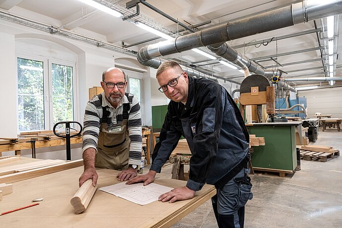 Der Bauhof der Firma in Wilischthal kann sich sehen lassen – modern ausgestattet, hell und sauber. Jens Fischer pflegt engen Kontakt zu seinen Mitarbeitern. Mit Tischler Michael Hetzer bespricht er aktuell anstehende Projekte. / © Lukas Ullmann