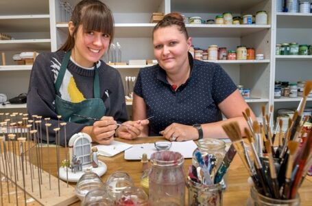 Unter Anleitung von Holzspielzeugmacherin Marie-Theres Langer (r.), die im Betrieb für die Ausbildung zuständig ist,bemalt Maria Hansen Schuhe für die Miniaturfigur Aschenbrödel. Foto: Kristian Hahn