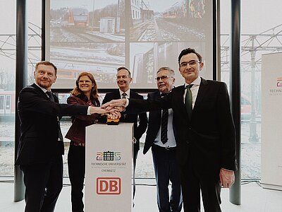 Mit der Inbetriebnahme weiterer moderner 5G-Mobilfunknetze steht im Erzgebirge zwischen Annaberg-Buchholz und Schwarzenberg nun eine komplette 5G-Infrastruktur für zukunftsweisende Forschung insbesondere im Eisenbahnsektor zur Verfügung. Dr. Volker Wissing, Bundesminister für Digitales und Verkehr, Sachsens Ministerpräsident Michael Kretschmer, Rolf Schmidt als Oberbürgermeister der Stadt Annaberg-Buchholz, Prof. Dr. Gerd Strohmeier als Rektor der Technischen Universität Chemnitz sowie Dr. Daniela Gerd tom Markotten, Vorständin für Digitalisierung und Technik der Deutschen Bahn, setzten die 5G-Infrastruktur der Technischen Universität (TU) Chemnitz heute mit einem symbolischen Knopfdruck in Betrieb. Sie vervollständigten damit die 5G-Versorgung im „Digitalen Testfeld Bahn“.